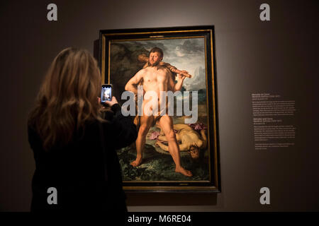 Amsterdam, Paesi Bassi. 6 Marzo, 2018. Un visitatore al Rijksmuseum a piedi attraverso la mostra 'High Society", che apre il 08 marzo 2018. Sulla parete è appeso un dipinto di Ercole da Hendrick Golktzius. Ritratti di potenti principi, eccentrico aristocratici e ricchi borghesi di epoche differenti può essere visto fino al 03 giugno 2018. Foto: Jeroen Jumelet/dpa - ATTENZIONE I REDATTORI: solo uso editoriale in connessione con le attuali relazioni sulle esposizioni. Credito: dpa picture alliance/Alamy Live News Foto Stock