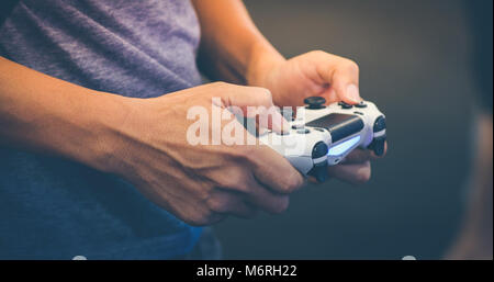 Uomini asiatici competitiva amici per giocare con i videogiochi eccitato e felice allegro a casa Foto Stock