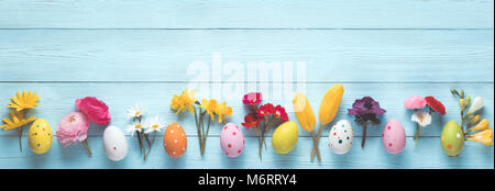 Uova di Pasqua e fiori di primavera su legno Foto Stock