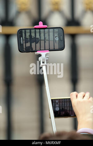 I turisti si scuotono per posizione per film il quotidiano cambio della guardia a Buckingham Palace di Londra la casa della regina Elisabetta 11 Foto Stock