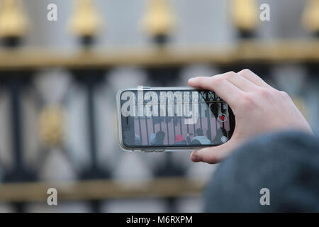 I turisti si scuotono per posizione per film il quotidiano cambio della guardia a Buckingham Palace di Londra la casa della regina Elisabetta 11 Foto Stock