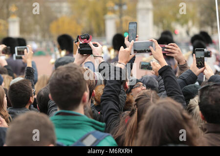 I turisti si scuotono per posizione per film il quotidiano cambio della guardia a Buckingham Palace di Londra la casa della regina Elisabetta 11 Foto Stock