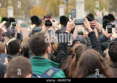 I turisti si scuotono per posizione per film il quotidiano cambio della guardia a Buckingham Palace di Londra la casa della regina Elisabetta 11 Foto Stock