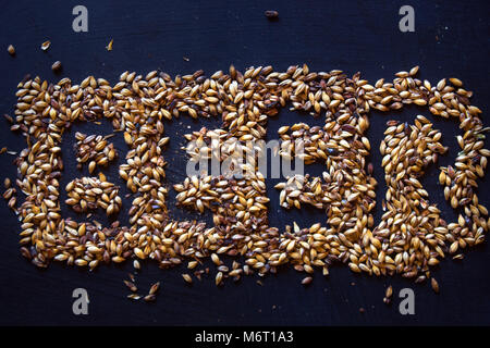 Vista superiore birra parola formata dal malto di orzo grani sulla lavagna Foto Stock