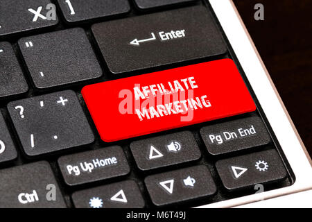Sulla tastiera del notebook il pulsante rosso scritto il marketing di affiliazione. Foto Stock