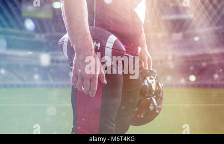 Closeup Ritratto di un forte muscolare di giocatore di football americano sulla grande stadio moderno campo con luci e razzi Foto Stock