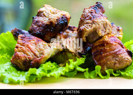 La carne di maiale shish kebab su un tavolo di legno. Foto Stock