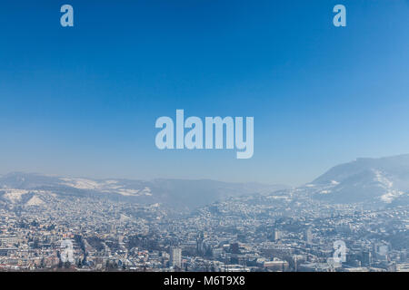 Vista aerea di Sarajevo durante un inverno pieno di sole pomeridiano, coperto di neve. Il centro storico con le sue moschee e minareti può essere visto in backgroun Foto Stock