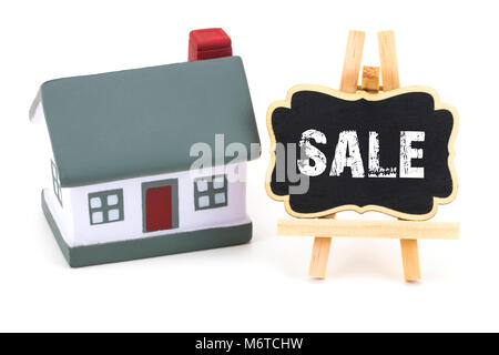 Modello in miniatura della casa e una lavagna con testo: vendita. Foto Stock