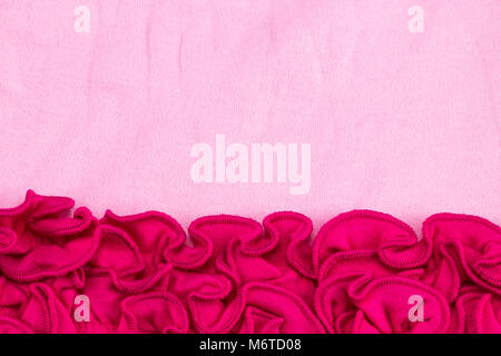 Il merletto Cornice di fiori vicino sul tessuto rosa texture. Foto Stock