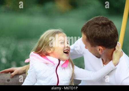 Concetto di istruzione:papà e figlia giocano nel parco su una S Foto Stock