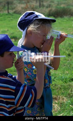 Due bambini guardando i bug attraverso pooter Foto Stock