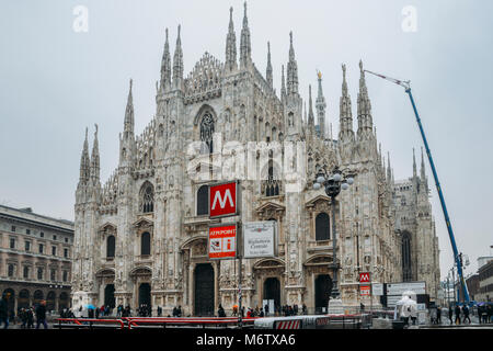 Facciata gotica del Duomo di Milano in Piazza del Duomo con lampade e segno della metropolitana e la linea M1 ingresso Foto Stock