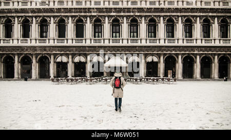 Venezia, Italia - 28 febbraio/1 marzo 2018 una donna guarda alle Procuratie Nuove in piazza San Marco durante una nevicata a Venezia, Italia. Un soffio di gelo chiamato "Bestia da est" ha afferrato la maggior parte di Europa nel mezzo dell'inverno del 2018, e a Venezia una nevicata ha coperto la città con il bianco, rendendolo affascinante e poetico per cittadini e turisti. © Simone Padovani / risveglio Foto Stock