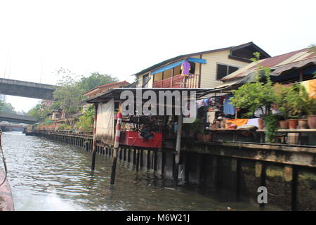 Graffiti tailandese e alloggiamento in contrasto con la moderna architettura. Foto Stock