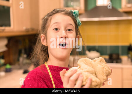 Allegro ragazza con un pezzo di pasta. Foto Stock