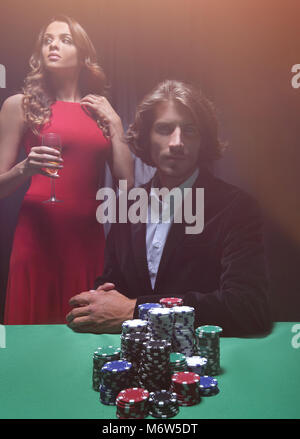 L uomo alla roulette tavolo circondato da belle donne Foto Stock