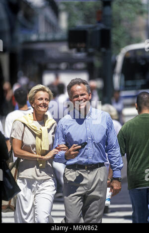 1997 caucasico storica Coppia di mezza età camminando in CROSSWALK MANHATTAN NEW YORK CITY USA Foto Stock