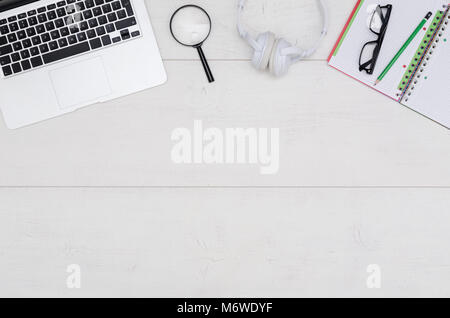 Ufficio tavolo scrivania con computer portatile e i materiali di consumo. Lay piatto con copia spazio bianco su sfondo di legno Foto Stock