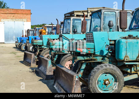 Trattore con una benna per scavare il suolo. Bulldozer e livellatrice. Foto Stock