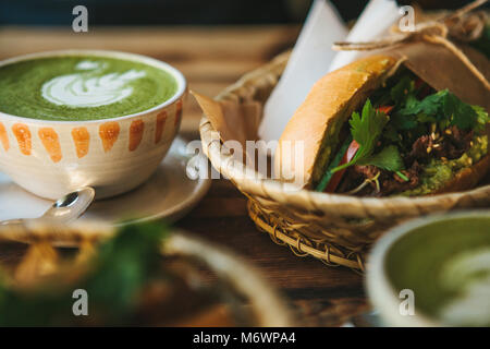 Tazza di ceramica con tè verde Matcha chiamato e un panino vicino Foto Stock