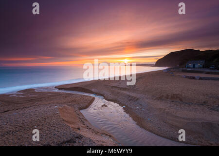 Seatown, Dorset, Regno Unito. Il 6 marzo 2018. Regno Unito Meteo. Livello alto nuvole oscura parzialmente il tramonto a Seatown su Jurassic Coast di Dorset. Credito Foto: Graham Hunt/Alamy Live News Foto Stock