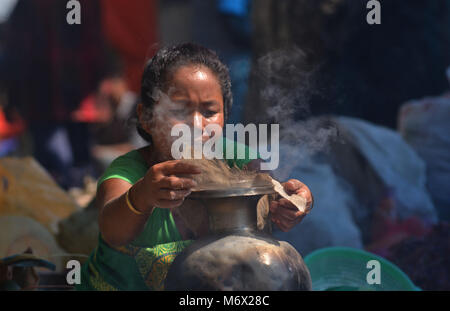 Dimapur, India Mar 07 2018: una donna cuoce pane locale in un mercato per la vendita alla vigilia della Giornata internazionale della donna in Dimapur, India nord orientale di stato del Nagaland. Foto Stock