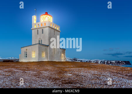 Dyrholaey faro al tramonto. La stazione di luce a Dyrholaey è stata fondata nel 1910, vicino al villaggio di Vik, sulla punta meridionale dell'Islanda. Foto Stock