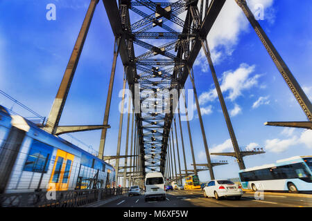 I mezzi di trasporto pubblici e privati di autovetture durante il traffico intenso Rush Hour guida oltre il Ponte del Porto di Sydney nella città di Sydney CBD da Western D Foto Stock