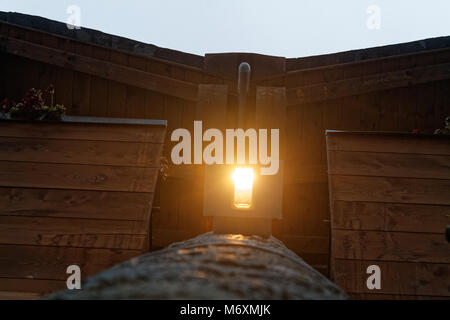 Lampada luce sotto il tetto in legno con travi in legno scuro. Foto Stock