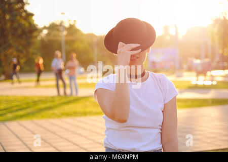 Bella donna faccia nascondere dietro hat mostra gli occhi Foto Stock