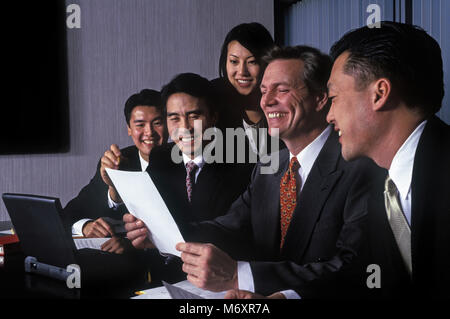 2000 fila storica di seduto asiatici e caucasici multi etnico business persone al tavolo da conferenza in Office SALA RIUNIONI Foto Stock