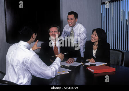 2000 insediato storico asiatici e caucasici multi etnico business persone al tavolo da conferenza in Office SALA RIUNIONI Foto Stock