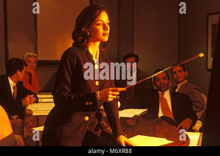 2000 Presentazione storica da donna caucasica al gruppo di multi etnico business persone che indossano tute in OFFICE SALA RIUNIONI Foto Stock