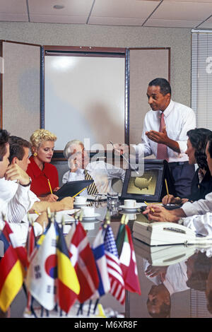 Storico 2000 AFRICAN AMERICAN BUSINESS uomo fa la presentazione al gruppo di multi etnico persone BUSINESS SALE RIUNIONI IN SALA CONFERENZE Foto Stock