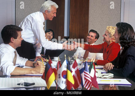 2000 STORICO BUSINESS caucasica l uomo e la donna handshake nel gruppo di multi etnico persone BUSINESS SALE RIUNIONI IN SALA CONFERENZE Foto Stock