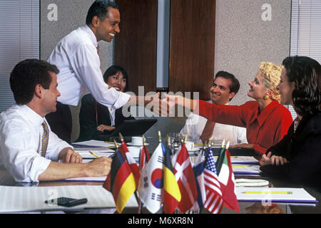 Storico 2000 AFRICAN AMERICAN BUSINESS MAN E CAUCASICO BUSINESS HANDSHAKE DONNA NEL GRUPPO DI multi etnico persone BUSINESS SALE RIUNIONI IN SALA CONFERENZE Foto Stock