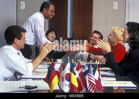 Storico 2000 AFRICAN AMERICAN BUSINESS MAN E CAUCASICO BUSINESS HANDSHAKE DONNA NEL GRUPPO DI multi etnico persone BUSINESS SALE RIUNIONI IN SALA CONFERENZE Foto Stock