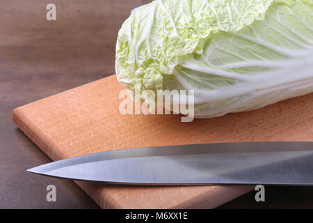 Fresche e mature cavolo cinese e il coltello sul tagliere. Ingredienti per insalata. Pronta per la cottura. Foto Stock