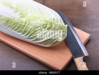 Fresche e mature cavolo cinese e il coltello sul tagliere. Ingredienti per insalata. Pronta per la cottura. Foto Stock