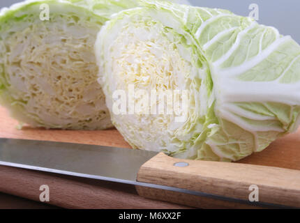 Fresche e mature cavolo cinese e il coltello sul tagliere. Ingredienti per insalata. Pronta per la cottura. Close-up. Foto Stock