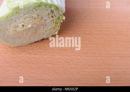 Fresche e mature cavolo cinese e il coltello sul tagliere. Ingredienti per insalata. Pronta per la cottura. Close-up. Foto Stock