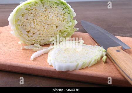 Fresche e mature cavolo cinese e il coltello sul tagliere. Ingredienti per insalata. Pronta per la cottura. Close-up. Foto Stock