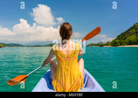 Giovane donna paddling una canoa durante la vacanza in sull isola di Flores, Indonesia Foto Stock