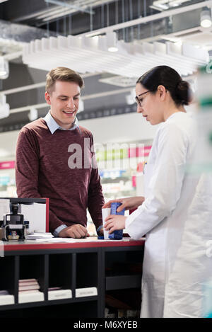 Soddisfazione del cliente ascoltando le raccomandazioni di un farmacista affidabile Foto Stock