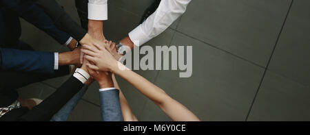 Vista aerea del team aziende mettendo le mani insieme all'ufficio. Ufficio lavoratori che fanno una pila di mani con copia spazio. Foto Stock