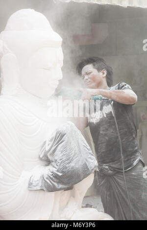 Uomo locale scultura in marmo del Buddha, Amarapura Mandalay, Myanmar (Birmania), l'Asia in febbraio - lavorare in marmo scultura in pietra workshop coperti di polvere Foto Stock