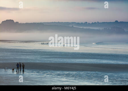 Nebbia di mare e figure pochi cani sulla Plage de KERLOC'H, Crozon Penisola, Finisterre, Bretagne, Francia Foto Stock