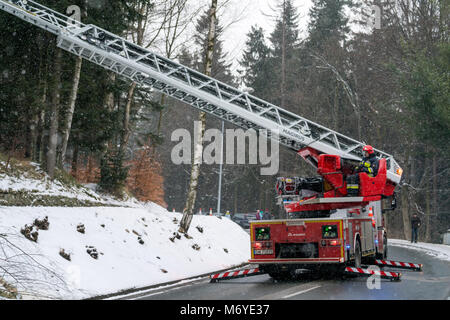 Karpacz, Polonia - Febbraio 2018 : Firefighter seduto nella sedia di controllo operativo estendibile un braccio di gru con i suoi colleghi in esso il taglio di rami o Foto Stock