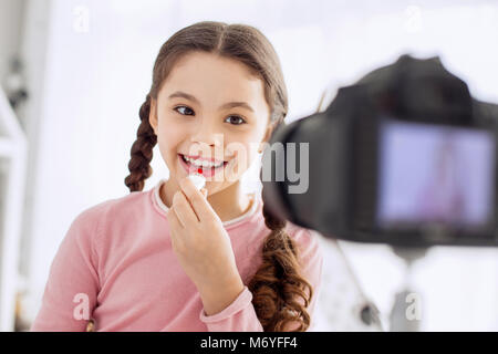 Pretty girl mettendo sul LIP BALM durante il makeup tutorial Foto Stock